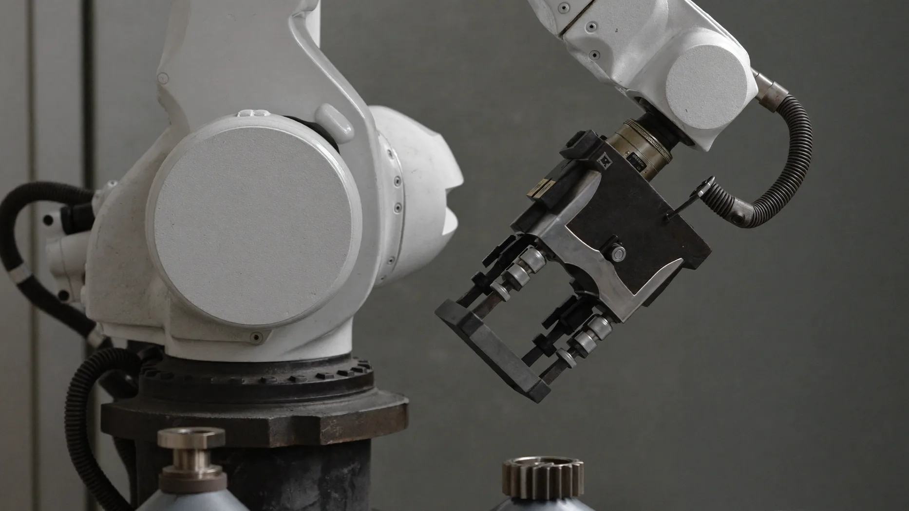 Pinza di un braccio robotico collaborativo bianco su banco di assemblaggio